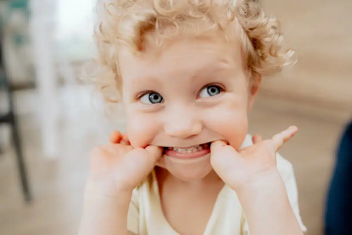 Niño pequeño enseñando sus dientes de leche con una sonrisa