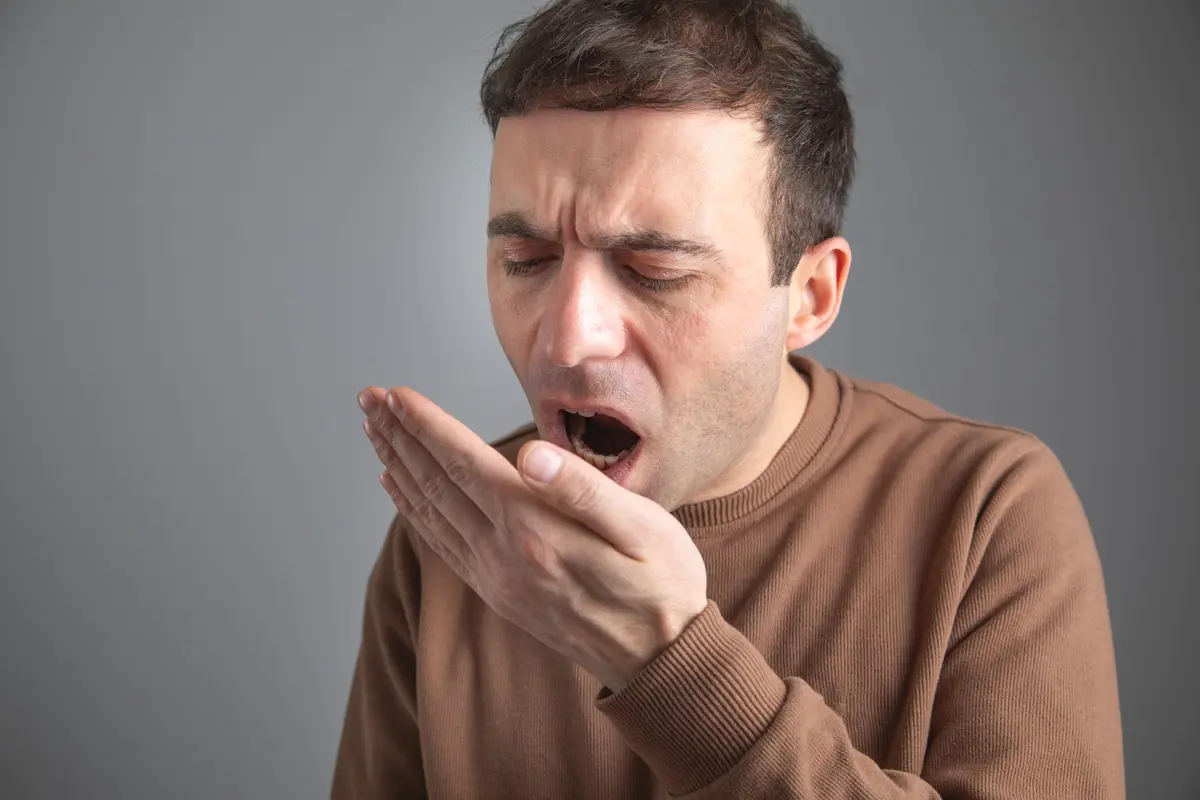 Hombre comprobando su aliento — mal aliento y halitosis