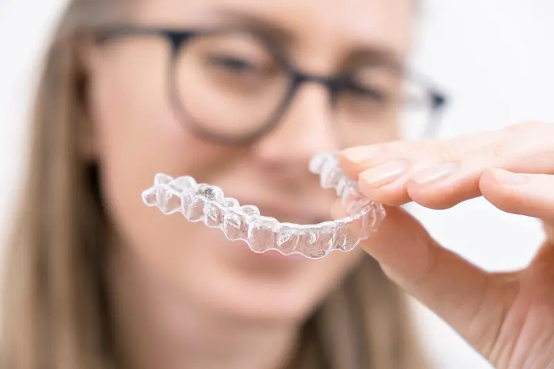 Paciente sonriendo con alineadores transparentes de ortodoncia invisible