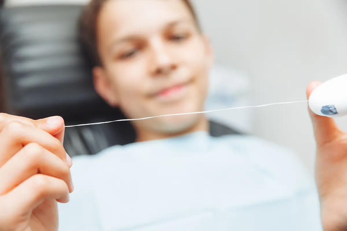 Higienista bucodental de DentoSmile explicando el uso correcto del hilo dental a paciente