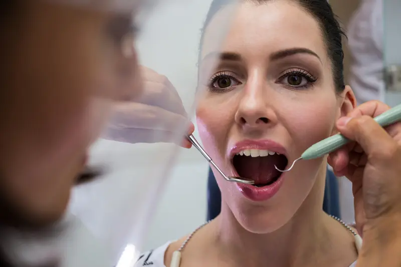 Exploración periodontal con sonda e instrumental en consulta dental